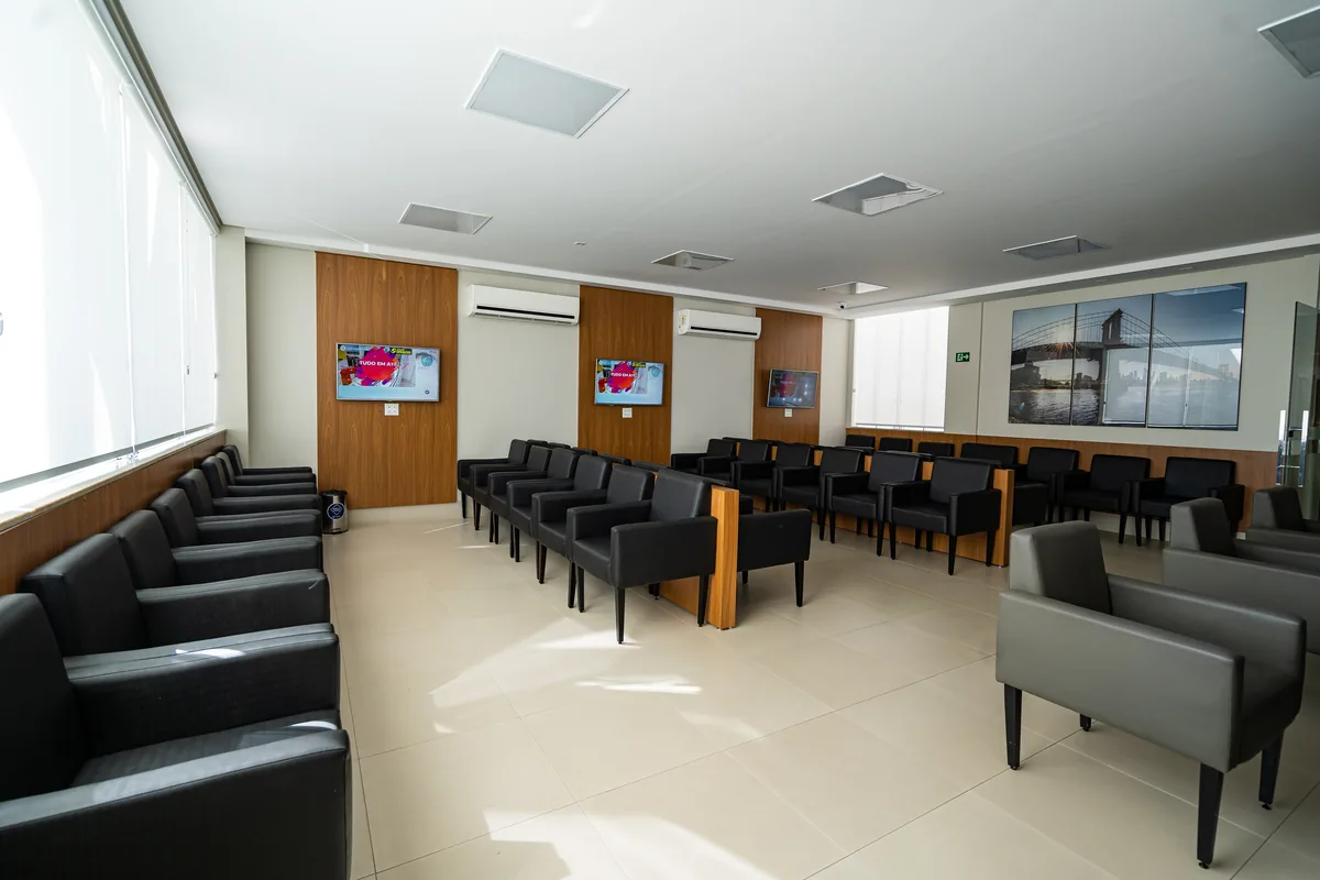Ampla sala de espera do Visare Hospital de Olhos com cadeiras e televisores